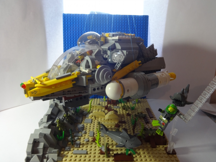 LEGO MOC - Submersibles -  Глубоководный исследовательский батискаф:  Команда 'ЛЕГО-ОГЕЛ' спустилась ко дну океана и в скале они увидели сундук который обнаружил аквалангист. Но его охраняют акулы и пока они поплыли за аквалангистом, вылазит механическая рука.<br />
 Длина батискафа-30 см, высота-15 см,<br />
ширина-16,5 см класс-ЛЕГО. 